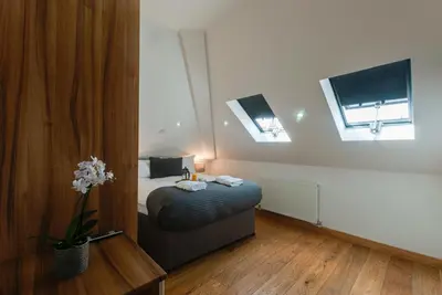 a bedroom with a bed and two windows at Base Serviced Apartments - Sir Thomas Street in Liverpool