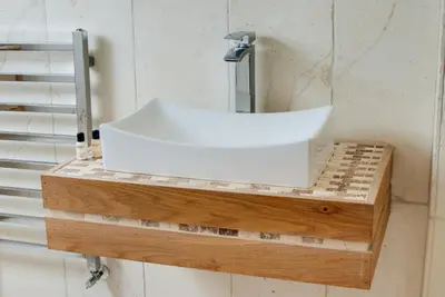 a white sink on top of a wooden shelf at Base Serviced Apartments - Sir Thomas Street in Liverpool