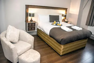 a hotel room with a bed and a chair at Base Serviced Apartments - Sir Thomas Street in Liverpool