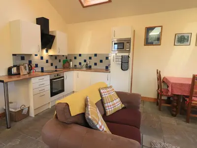 a living room with a couch and a kitchen at Swallow cottage, Over Kellet in Over Kellet