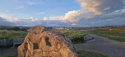 a stone sculpture of a face on a field at Port Haverigg Millom in Millom