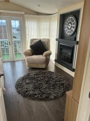 a living room with a chair and a fireplace at Port Haverigg Millom in Millom