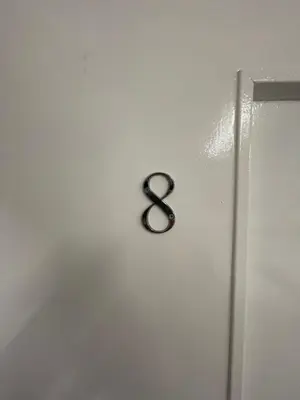 a black number eight on a white wall at County serviced accommodation in Liverpool