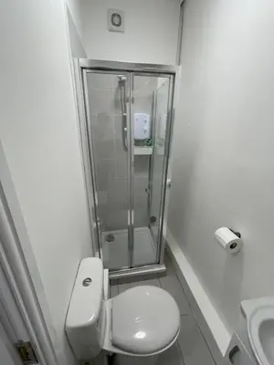 a bathroom with a shower and a toilet and a sink at County serviced accommodation in Liverpool