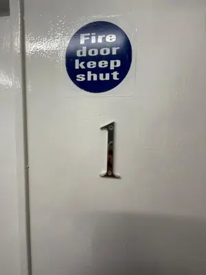 a sign on a door that reads fire dog keep shift at County serviced accommodation in Liverpool