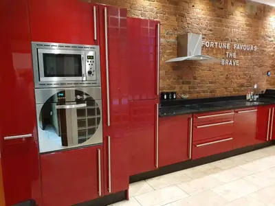 a red kitchen with a microwave and red cabinets at Infinity PartyPadsLiverpool Hen and Stag Welcome in Liverpool