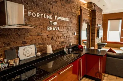 a kitchen with a sink and a brick wall at Infinity PartyPadsLiverpool Hen and Stag Welcome in Liverpool