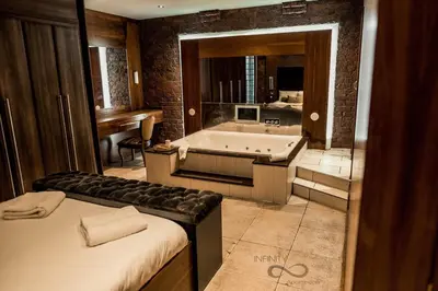 a bathroom with a tub and a sink and a bath tub at Infinity PartyPadsLiverpool Hen and Stag Welcome in Liverpool