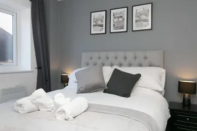 a bedroom with a white bed with stuffed animals on it at Stunning 2 Bedroom Apartment in Wallasey in Wallasey