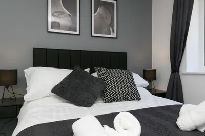 a bedroom with a bed with white sheets and pillows at Stunning 2 Bedroom Apartment in Wallasey in Wallasey