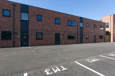 an empty parking lot in front of a brick building at Stunning 2 Bedroom Apartment in Wallasey in Wallasey
