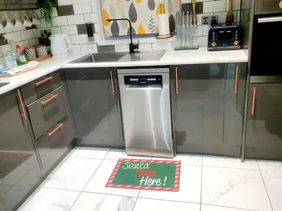a kitchen with a stainless steel refrigerator and a sign on the floor at Families Only - Pet Friendly sleeps 6 maximum NO PARTIES in Blackpool