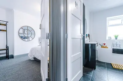 a white room with a bed and a bathroom at Families Only - Pet Friendly sleeps 6 maximum NO PARTIES in Blackpool