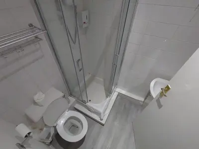 a small bathroom with a shower and a toilet at High Tide Hotel Oyo in Blackpool