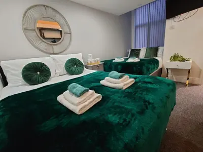 a bedroom with a green bed with towels on it at High Tide Hotel Oyo in Blackpool