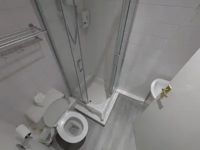 a small bathroom with a shower and a toilet at High Tide Hotel Oyo in Blackpool