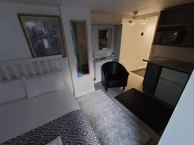 a bedroom with a bed and a desk and a chair at High Tide Hotel Oyo in Blackpool