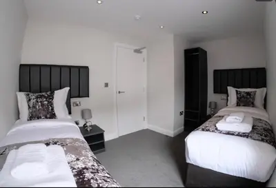 a bedroom with two beds with white sheets at Anelli Hotel in Southport