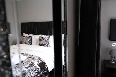 a bedroom with a bed with white sheets and pillows at Anelli Hotel in Southport