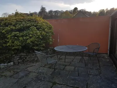 a patio with a table and two chairs and a fence at Cottage - Sleeps 4 - Pets Ok - Garden - Parking in Carnforth