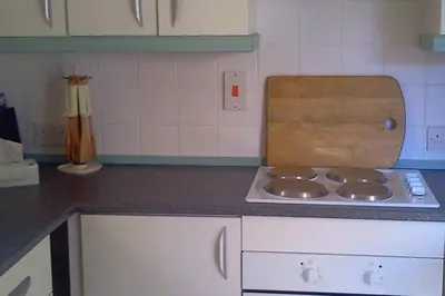 a kitchen with a stove and a counter top at Cottage - Sleeps 4 - Pets Ok - Garden - Parking in Carnforth