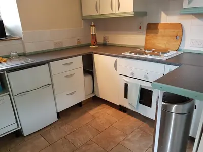 a kitchen with white cabinets and a counter top at Cottage - Sleeps 4 - Pets Ok - Garden - Parking in Carnforth