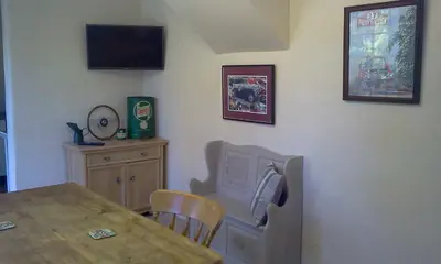 a dining room with a table and a television on the wall at Cottage - Sleeps 4 - Pets Ok - Garden - Parking in Carnforth