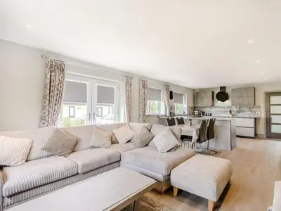 a living room with a couch and a kitchen at Willows Cottage in Blackburn