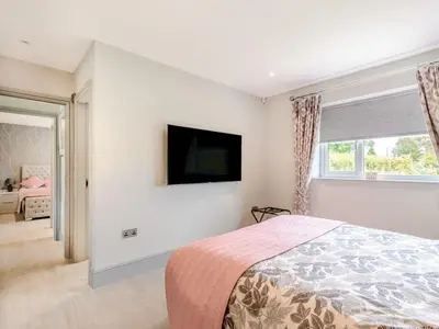 a bedroom with a bed and a tv on the wall at Willows Cottage in Blackburn