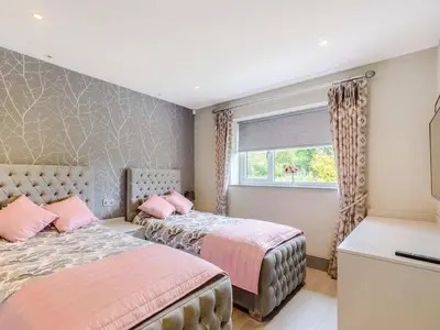 a bedroom with two beds and a window at Willows Cottage in Blackburn