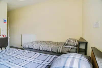 a bedroom with two beds and a desk and a bed at OYO Castle Hotel, Accrington in Accrington