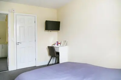 a bedroom with a bed and a desk with a monitor at OYO Castle Hotel, Accrington in Accrington