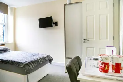 a bedroom with a bed and a table and a mirror at OYO Castle Hotel, Accrington in Accrington