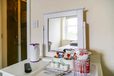 a bathroom counter with a mirror and a table with toothbrushes at OYO Castle Hotel, Accrington in Accrington