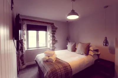 a bedroom with a bed with a teddy bear on it at The Tavern at Hale in Milnthorpe