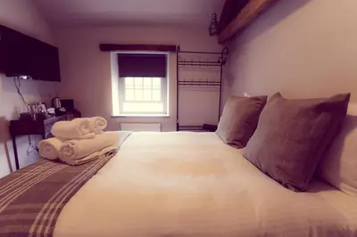 a bedroom with a large bed with towels on it at The Tavern at Hale in Milnthorpe