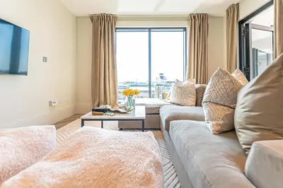 a living room with two couches and a large window at NOVU Apartments Liverpool Waterfront in Liverpool