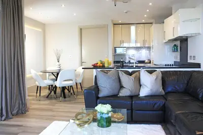 a living room and kitchen with a couch and a table at NOVU Apartments Liverpool Waterfront in Liverpool