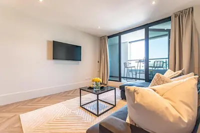 a living room with a couch and a table at NOVU Apartments Liverpool Waterfront in Liverpool