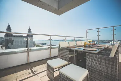 a balcony with a table and chairs on a building at NOVU Apartments Liverpool Waterfront in Liverpool