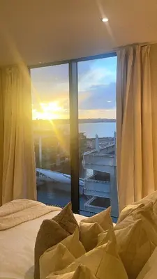 a bedroom with a window with a view of the ocean at NOVU Apartments Liverpool Waterfront in Liverpool