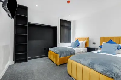 a hotel room with two beds and a tv at Winter Garden Apartments by Sasco in Blackpool