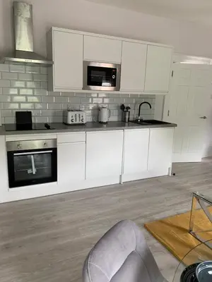 a kitchen with white cabinets and a sink at Winckley Square Residences in Preston