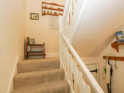 a staircase in a home with a white stair case at Tyee Cottage in Carnforth