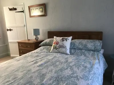 a bedroom with a bed with a pillow and a nightstand at Tyee Cottage in Carnforth