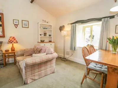 a living room with a couch and a table at Tyee Cottage in Carnforth