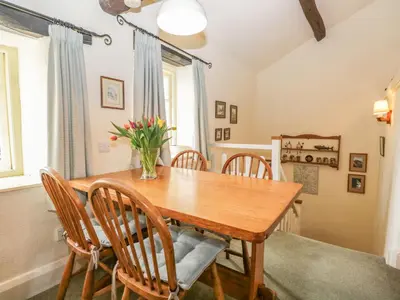 a dining room with a wooden table and chairs at Tyee Cottage in Carnforth