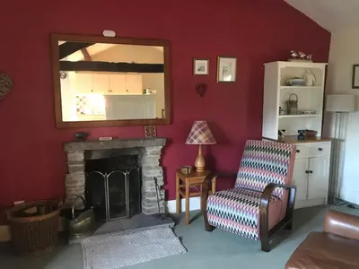 a living room with a fireplace and a mirror at Tyee Cottage in Carnforth