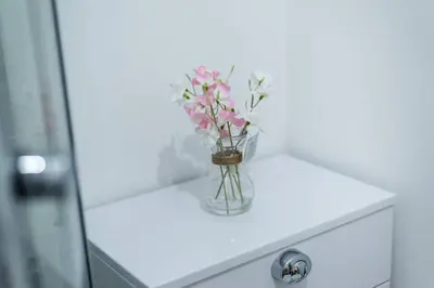 a vase filled with pink flowers sitting on a counter at Liverpool City Centre - Fabulous 3 En-suite Bedrooms - Sleeps 10 People in Liverpool