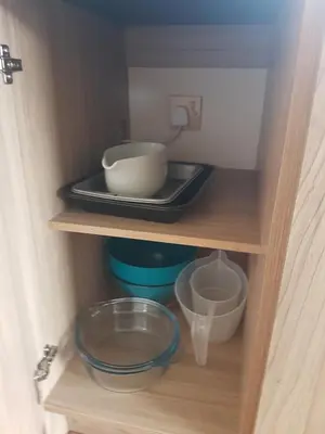 a cupboard with a plate and bowls on a tray at KINGDOM HOLIDAY PARK in Haverigg